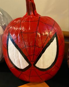 a spiderman pumpkin sitting on top of a table