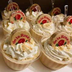 several cupcakes with whipped cream and strawberries on top are arranged in plastic cups