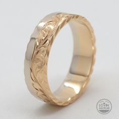 a wedding ring with an engraved design on the outside and inside, in yellow gold