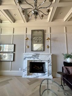 a living room filled with furniture and a fire place under a fancy chandelier