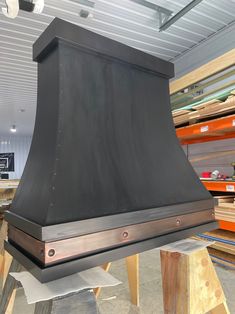 a large black stove top sitting inside of a room filled with wooden boards and shelves