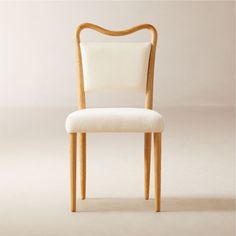 a wooden chair with a white upholstered seat and backrest, against a plain background