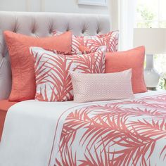 a bed with orange and white pillows on top of it