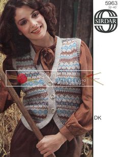 the woman is holding a stick and wearing a knitted vest with flowers on it