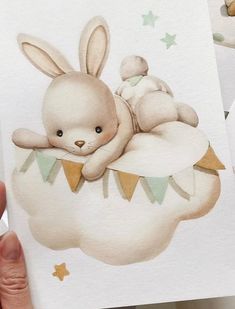 a hand holding up a card with an image of a bunny and baby rabbit on it