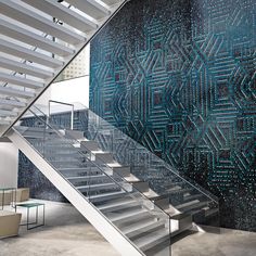 a stair case in front of a wall with blue and white designs on the side