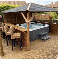 a hot tub sitting on top of a wooden deck next to a table and chairs