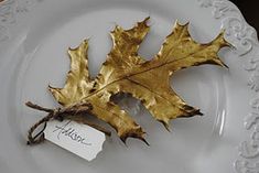 a plate with a leaf on it and a name tag attached to the edge that says autumn