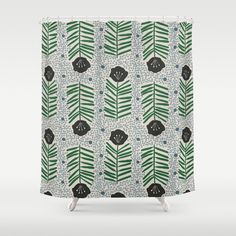 a shower curtain with green leaves and dots on the bottom, in front of a white background