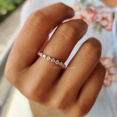 a woman's hand with a diamond ring on her left hand and the middle finger