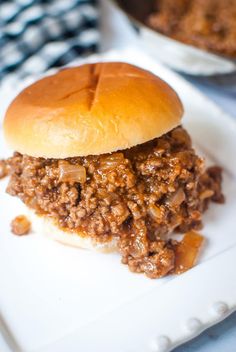 a sloppy joe sandwich sitting on top of a white plate