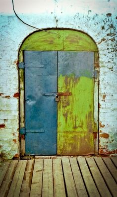 an old door is painted green and blue