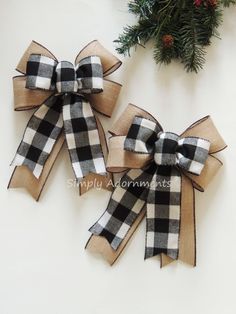 two black and white plaid bows with pine branches in the background