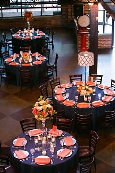 the tables are set with orange and black linens for an elegant dinnereon party