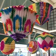 colorful paper fans are hanging from the ceiling