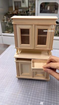 a hand is holding a dollhouse furniture set