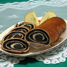 an apple and cinnamon roll on a plate with some slices cut in half, ready to be eaten