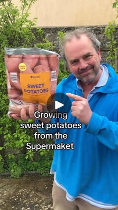 a man holding up some sweet potatoes from the supermaket in his hand