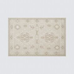 a beige rug with an intricate design on the bottom and sides, in front of a white background