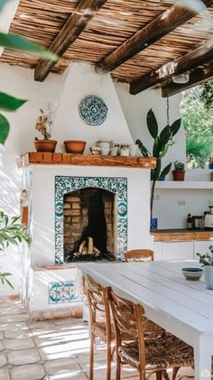 a kitchen with a fireplace and potted plants