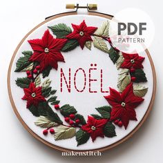 a cross stitch christmas wreath with poinsettis and the word noel