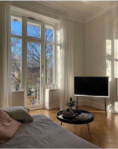 a living room filled with furniture and a flat screen tv on top of a wooden floor