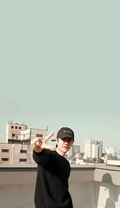 a man standing on top of a roof with his hand in the air