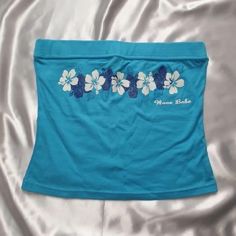 a women's blue skirt with white flowers on the side and name in front