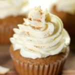 cupcakes with white frosting and cinnamon sprinkles on the top