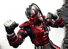 a red and black robot is holding his fist up