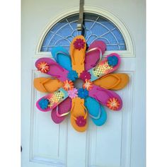 a door wreath with flip flops and flowers on it