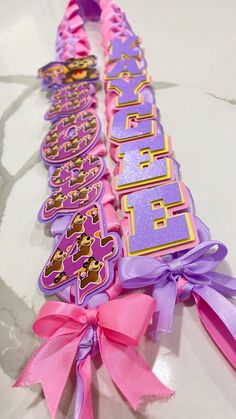 two pink and purple ribbons with the words happy birthday written in large letters on them