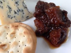 a plate with crackers, cheese and jelly on it's side is shown