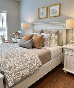 a bedroom with a bed, nightstands and two pictures on the wall