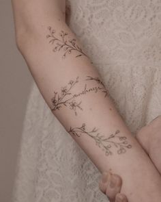 a woman's arm with flowers on it and the word love written in cursive writing