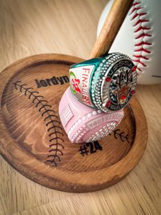 a baseball bat and some balls on top of a wooden base with writing underneath it