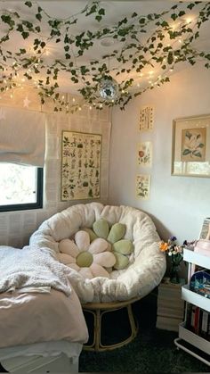 a bedroom decorated in white with lots of greenery on the ceiling and lights hanging from the ceiling