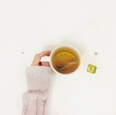 a person is holding a cup of tea