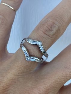 a woman's hand with two rings on it and one is wearing a diamond ring