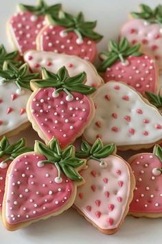 some decorated cookies with pink and white frosting on them are arranged in the shape of strawberries