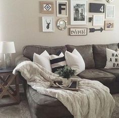 a living room filled with lots of furniture and pictures on the wall above it's couch