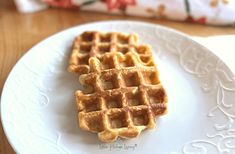 two waffles on a white plate sitting on a table