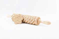 a wooden rolling pin sitting on top of a white surface