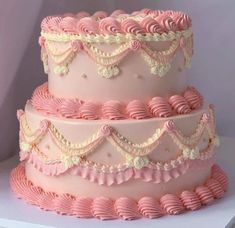 a three tiered cake with pink icing and ruffles on it's sides