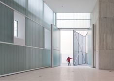 a person standing in an empty room with doors open