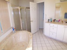 a bath room with a tub a sink and a mirror