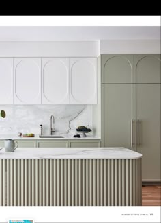 a kitchen with white cabinets and marble counter tops