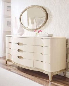 a white dresser sitting in front of a mirror