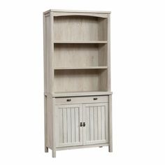 a white bookcase with two doors and drawers on the bottom, in front of a white background