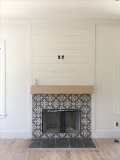 an empty living room with a fireplace and white walls